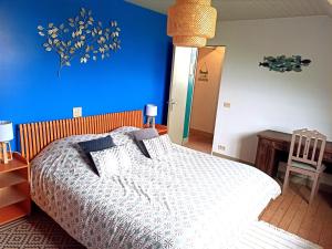 - une chambre dotée d'un lit avec un mur bleu dans l'établissement Les Sableaux, les portes du Marquenterre, à Saint-Quentin-en-Tourmont