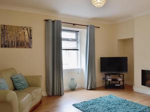 a living room with a couch and a television at Kirkview in Dundonald