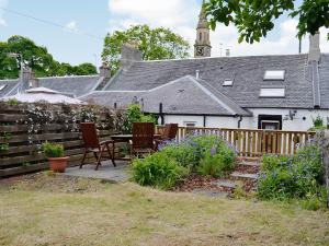 a garden with chairs and a table in front of a house at Kirkview in Dundonald