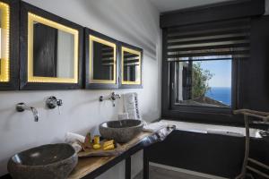 un bagno con due lavandini e una finestra di Myconian Utopia Relais & Chateaux a Elia Beach