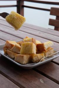 un plato de pan en una mesa con un trozo de comida en Aroonsri Thara, en Ratchaburi