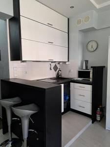 a kitchen with a black counter and white cabinets at Apartament Żeglarska 4 in Giżycko