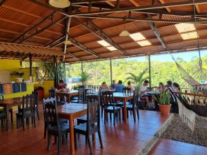 a restaurant with tables and chairs and people sitting at them at Cabinas Pura Vida B&B and Tour Operator in Drake