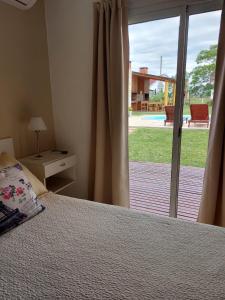 チャハリにあるComplejo Amareloのベッドルーム1室(ベッド1台付)、スライド式ガラスドアが備わります。