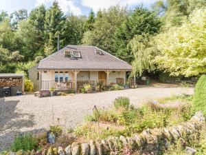 een huis met een grindoprit en een tuin bij The Mews - a cottage with a spectacular lake view in Port of Menteith