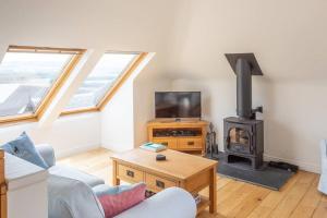 uma sala de estar com lareira e fogão em The Mews - a cottage with a spectacular lake view em Port of Menteith