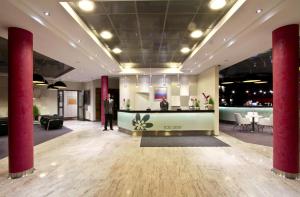 a lobby with a man standing in the middle of a room at Hotel Szafran in Czeladź