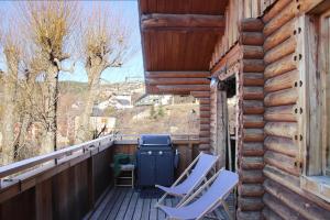 a balcony with two chairs and a trash can at Chalet Shaimoa in Font-Romeu-Odeillo-Via