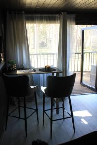 una mesa y sillas en una habitación con porche en Little Amber, en Bernāti