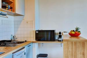 uma cozinha com um micro-ondas e uma tigela de fruta no balcão em Le Blue Lagoon - apt T2 Cap Homard em Grand Fond