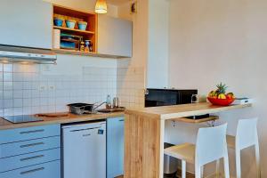uma cozinha com armários azuis e electrodomésticos brancos em Le Blue Lagoon - apt T2 Cap Homard em Grand Fond