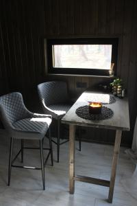 einen Tisch und zwei Stühle mit einer Kerze drauf in der Unterkunft Little Amber in Bernāti