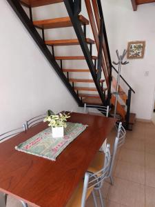 a dining room with a wooden table and stairs at Complejo Amarelo in Chajarí