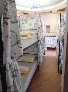 a room with three bunk beds with curtains at Sun city hostel in Yerevan
