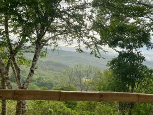 a wooden fence with a view of a mountain at Ecohotel La Reserva in Piojó