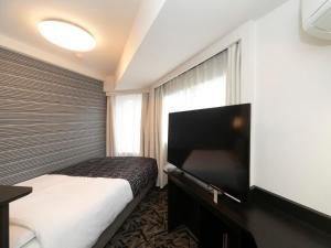 a hotel room with a bed and a window at APA Hotel Kobe-Sannomiya in Kobe