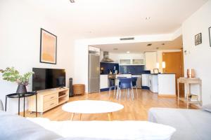sala de estar de planta abierta y cocina con armarios azules en Espectacular vivienda con piscina climatizada, en Castellón de la Plana