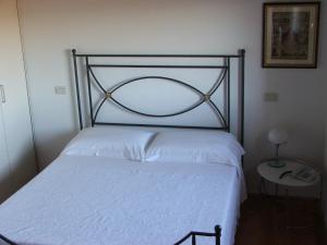 een slaapkamer met een wit bed met een metalen frame bij Palazzetto Ardi in Torri di Confine