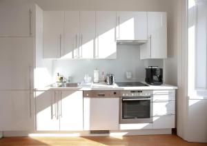a white kitchen with a sink and a stove at Long Term Rentals in Vienna