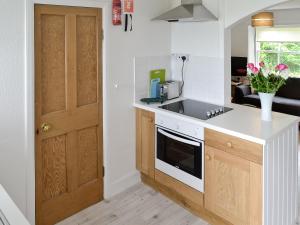 a kitchen with a sink and a stove top oven at Shore Cottage in Carsluith