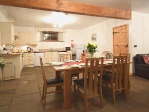 a kitchen and dining room with a wooden table and chairs at The Barn - 27977 in Whalley