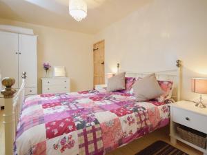 um quarto com uma cama com uma colcha colorida em The Barn - 27977 em Whalley