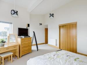 Somerford KeynesにあるSquirrels Leapのベッドルーム(ベッド1台、デスク、テレビ付)