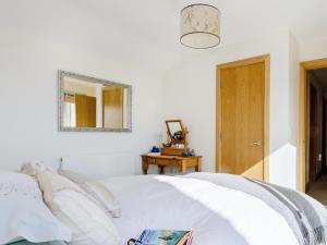 Somerford KeynesにあるSquirrels Leapのベッドルーム(白いベッド1台、鏡付)