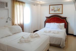 sypialnia z dwoma łóżkami z łukami w obiekcie RedDoorz at Caree Boutique Hotel Bulan Sorsogon w mieście Bulan
