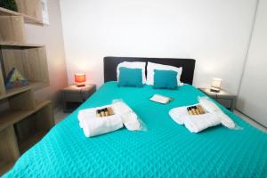 um quarto com uma cama verde e 2 almofadas em Orchidée YourHostHelper em Cannes