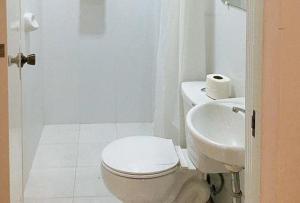 biała łazienka z toaletą i umywalką w obiekcie RedDoorz at Caree Boutique Hotel Bulan Sorsogon w mieście Bulan