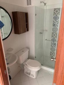 a bathroom with a toilet and a glass shower at Apartamento Cerca al Parque el Café in Montenegro