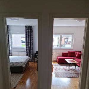 - un salon avec un canapé rouge et un lit dans l'établissement VIP 2 Apartment, à Visoko