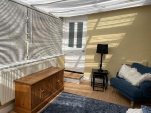 a living room with a blue couch and a window at The Corner House, 36, Broadway Road, in Evesham