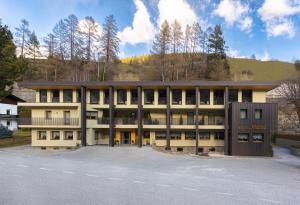 a large building with a mountain in the background at Hotel Maibad in Vipiteno