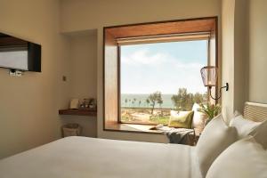 um quarto com uma cama e uma janela com vista em RUBENS BOUTIQUE HOTEL em Phan Thiet