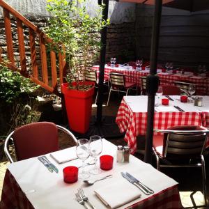 une table avec des nappes rouges et blanches sur une terrasse dans l'établissement L'Estaminet, à Mazille