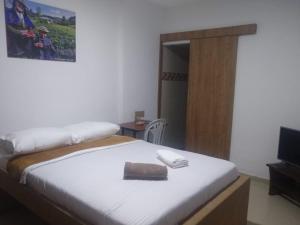a bedroom with a bed with a phone on it at ALOJAMIENTO Popayán - Viajes Sin Límites in Popayan