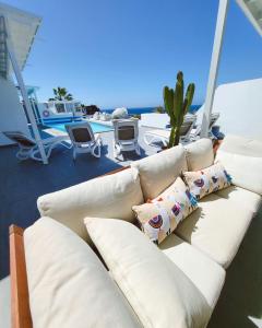 a white couch with pillows sitting on a patio at Villa Sunset Paradise with panoramic sea view, first line, sunsets in Playa Blanca