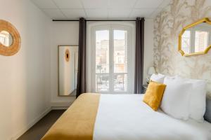 Schlafzimmer mit einem großen weißen Bett und einem Fenster in der Unterkunft Cosy 3 bedrooms apartment - Le Marais in Paris