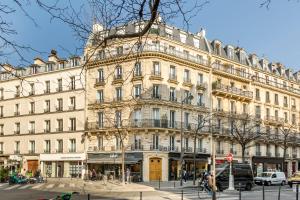 ein großes weißes Gebäude in einer Stadtstraße in der Unterkunft Cosy 3 bedrooms apartment - Le Marais in Paris
