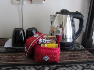 a counter top with a coffee pot and a red bag at Galang Kangin Bungalows in Amed