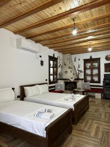a bedroom with two beds and a fireplace at Guest House Iljesa in Berat