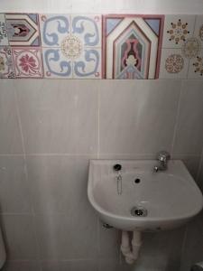 a white sink in a bathroom with tiles on the wall at FAST Wifi 400 Mbps Tiny House in Bacolod City in Bacolod