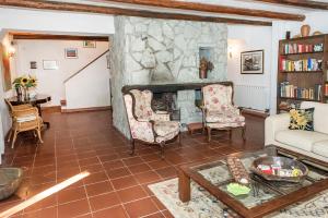 Casale della Luna في أنكونا: غرفة معيشة بها موقد وأريكة وكراسي
