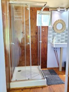 a shower with a glass door next to a sink at Glamping at The Well in Franschhoek in Franschhoek