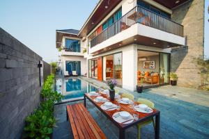 a patio with a table and chairs next to a pool at Hola Villa 2 by Ovui in Hiếu Nhơn +59 photos