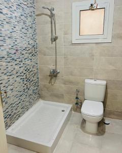 a bathroom with a shower and a toilet and a tub at 2BD Apartment In New Alamein City شقة فندقية مدينة العلمين الجديدة in El Alamein