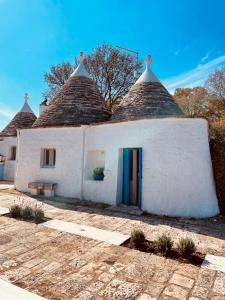 Biały dom z dachem krytym strzechą w obiekcie trulli mancinella w mieście Locorotondo