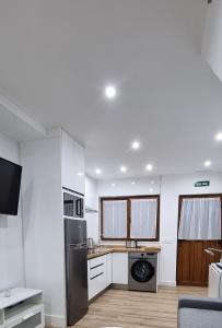 a kitchen with a refrigerator and a stove at Apartamentos Les Texuques in Nueva de Llanes +32 photos